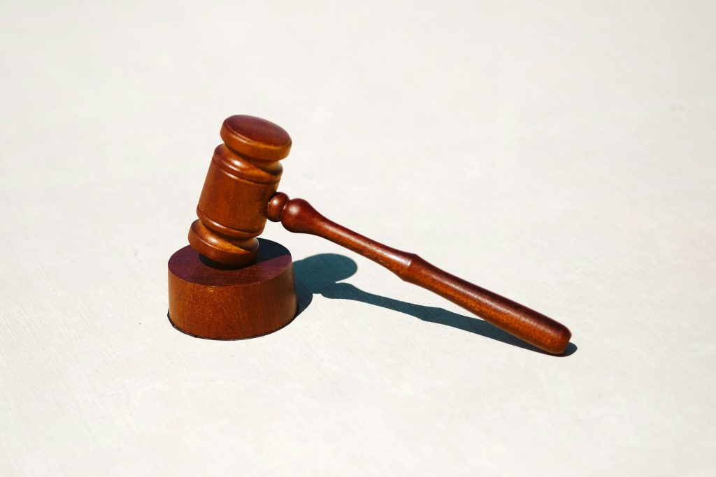 A wooden gavel resting on a wooden sound block.