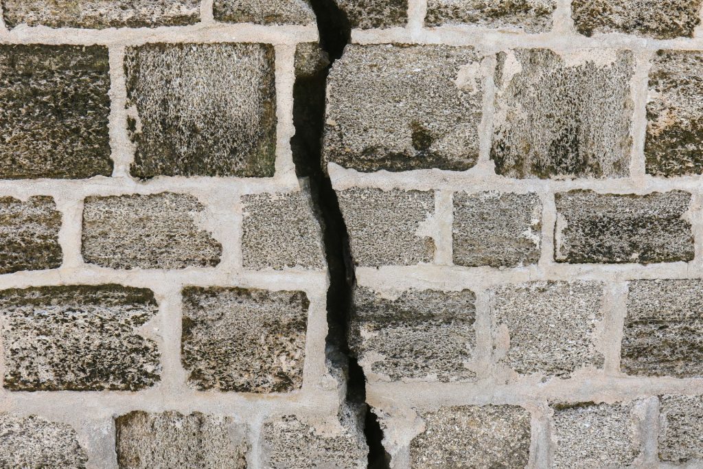 A gray brick wall with a crack running down the middle